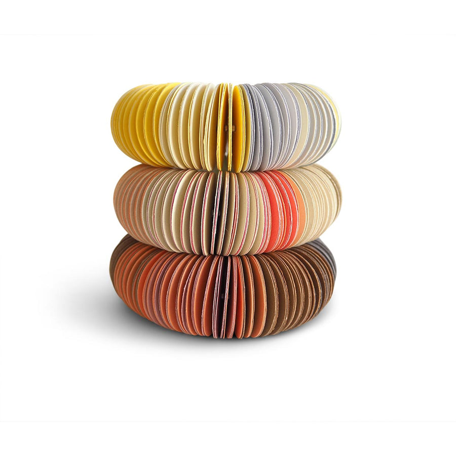 paper bangle stack. Yellow, peach, brown